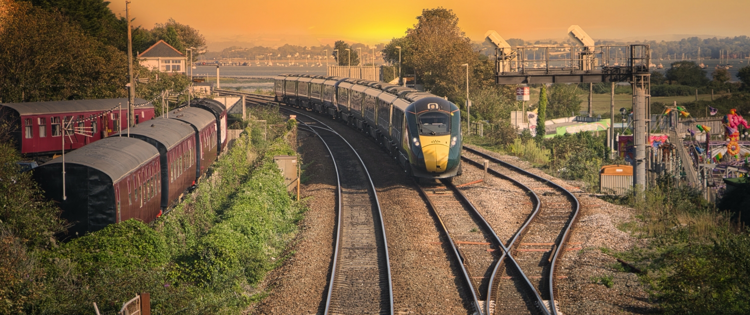 yellow and black train on rail tracks during sunset