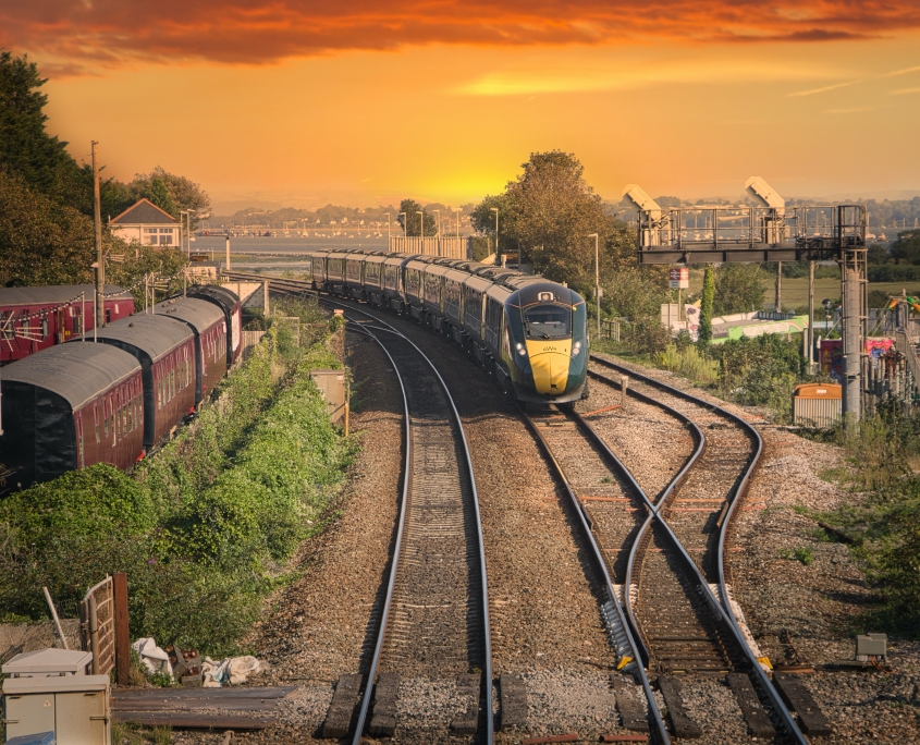 yellow and black train on rail tracks during sunset